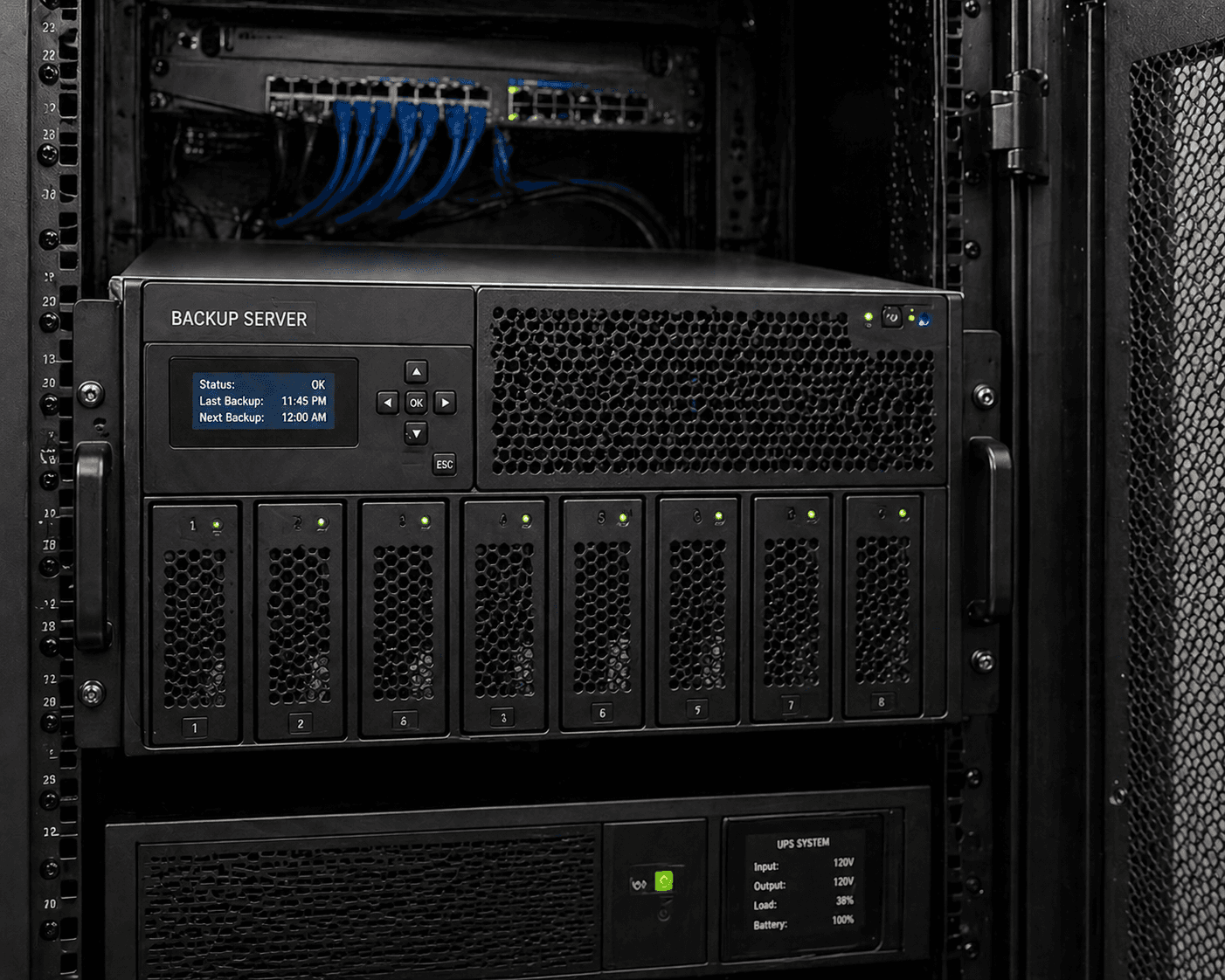 Rack-mounted backup server with LCD status display and eight drive bays with green lights.